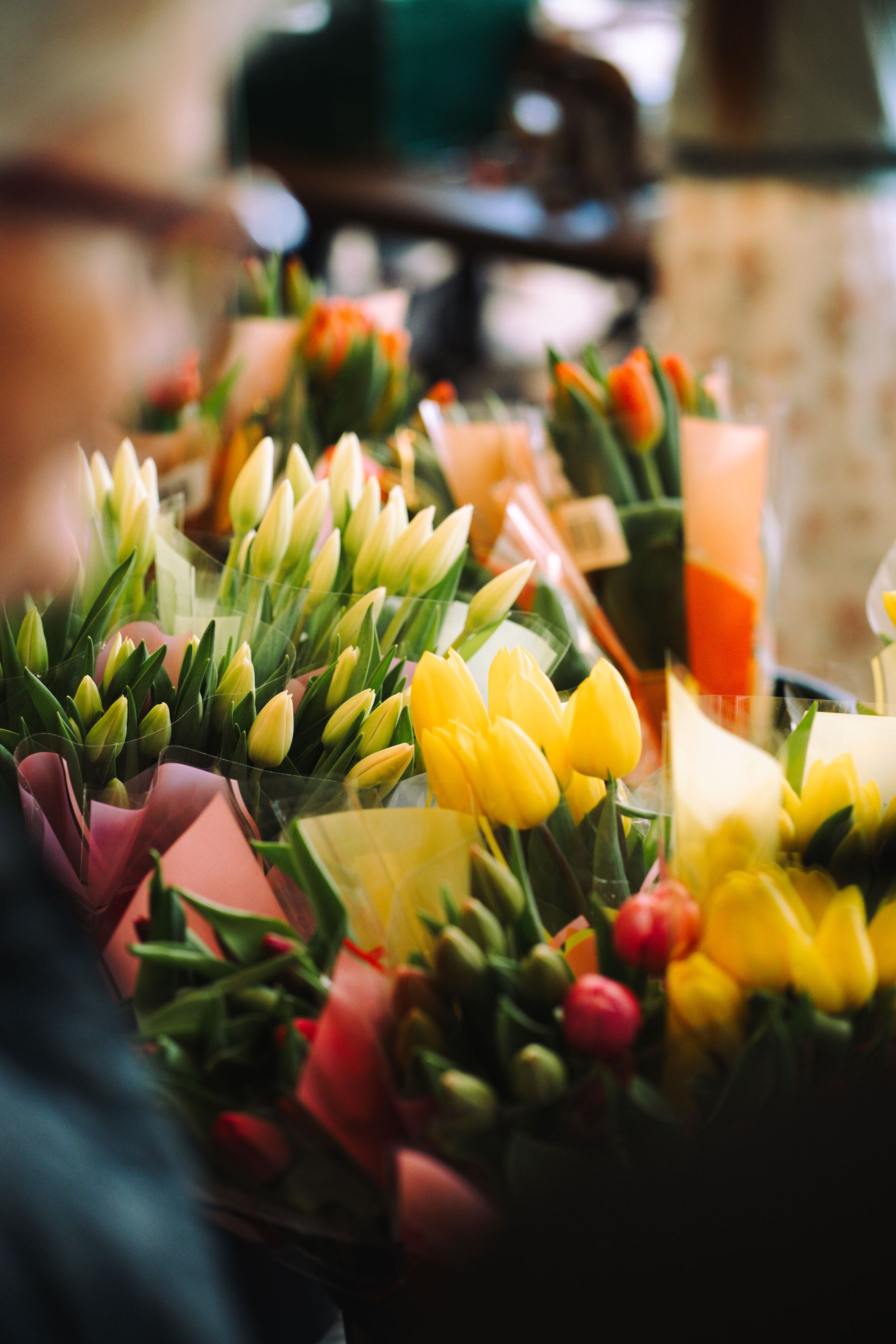 Colorful tulip bouquets wrapped in paper on display at a local flower market.