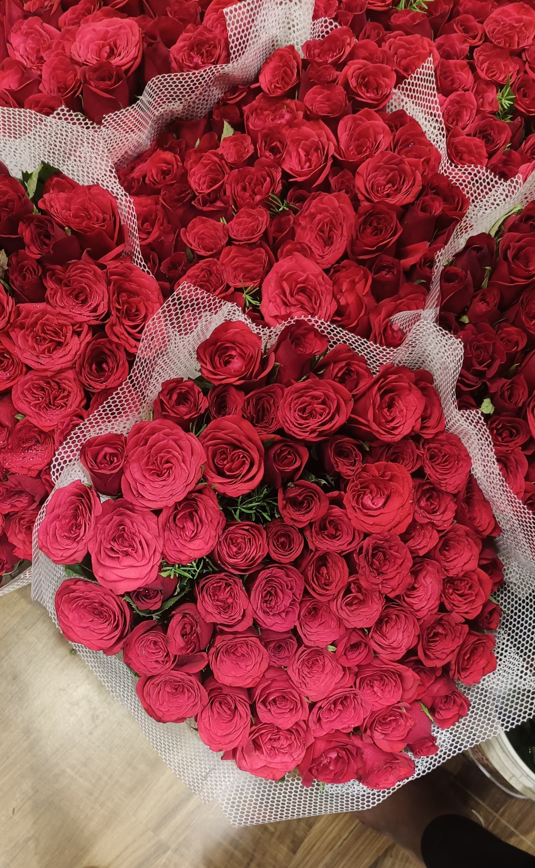 Beautifully arranged red roses in mesh wrapping, perfect for gifting or decoration.